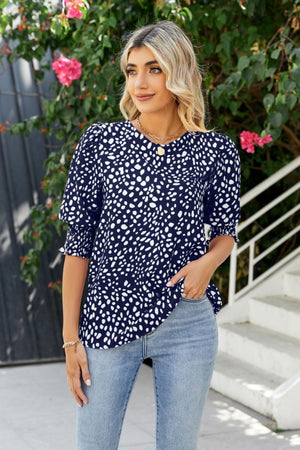 Dark blue blouse with white spot print, shirred short sleeves, and V-neck.