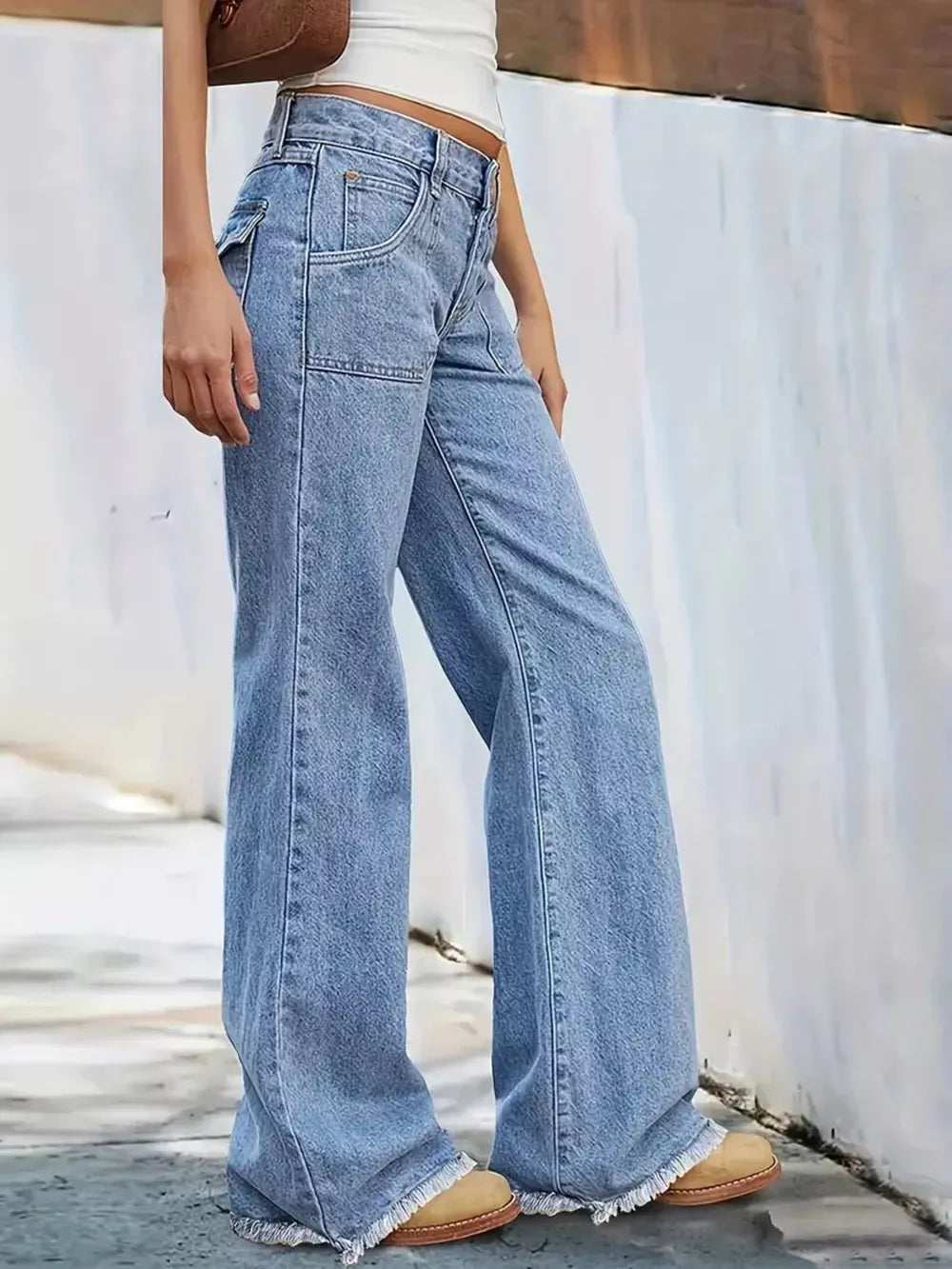 Light wash denim wide-leg jeans with frayed hem and button fly.