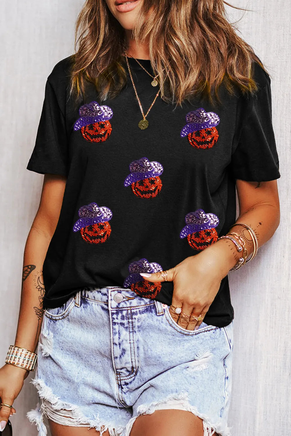 Black t-shirt with sequin pumpkin pattern, crew neck, short sleeves.