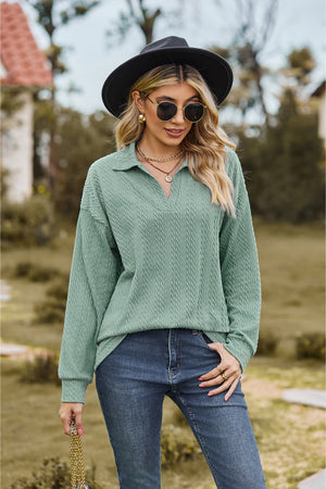 Sage green textured cable knit polo top with a V-neck and long sleeves.