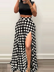 Chic black polka dot maxi skirt with a high slit and pockets.