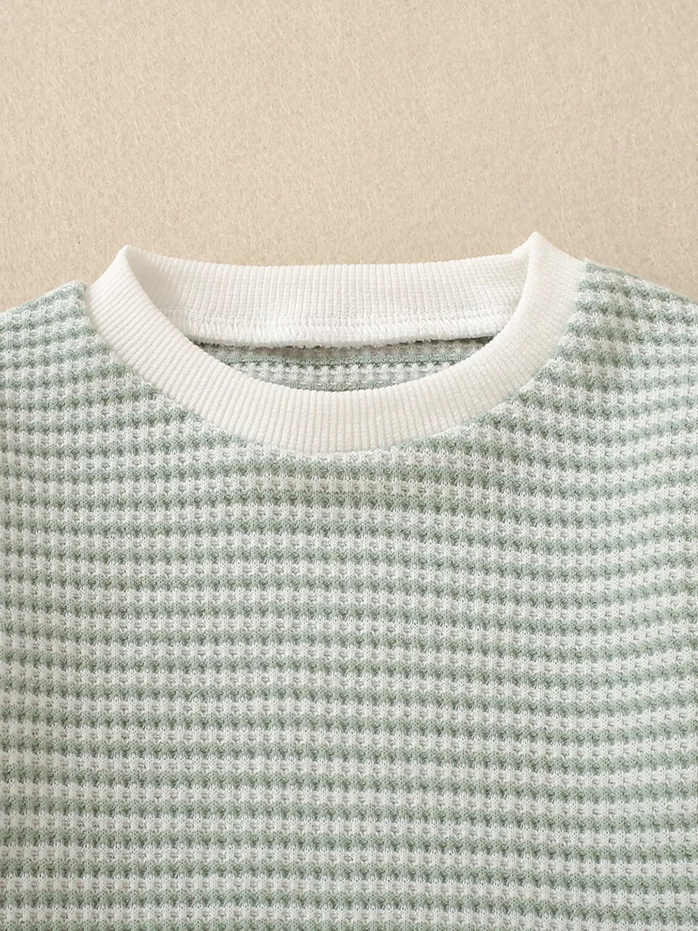 Baby knit set in light green waffle texture with white ribbed crew neck.