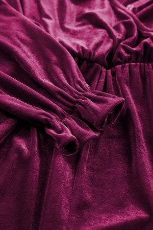 Burgundy velvet romper with ruffled cuffs and cinched waist detail.