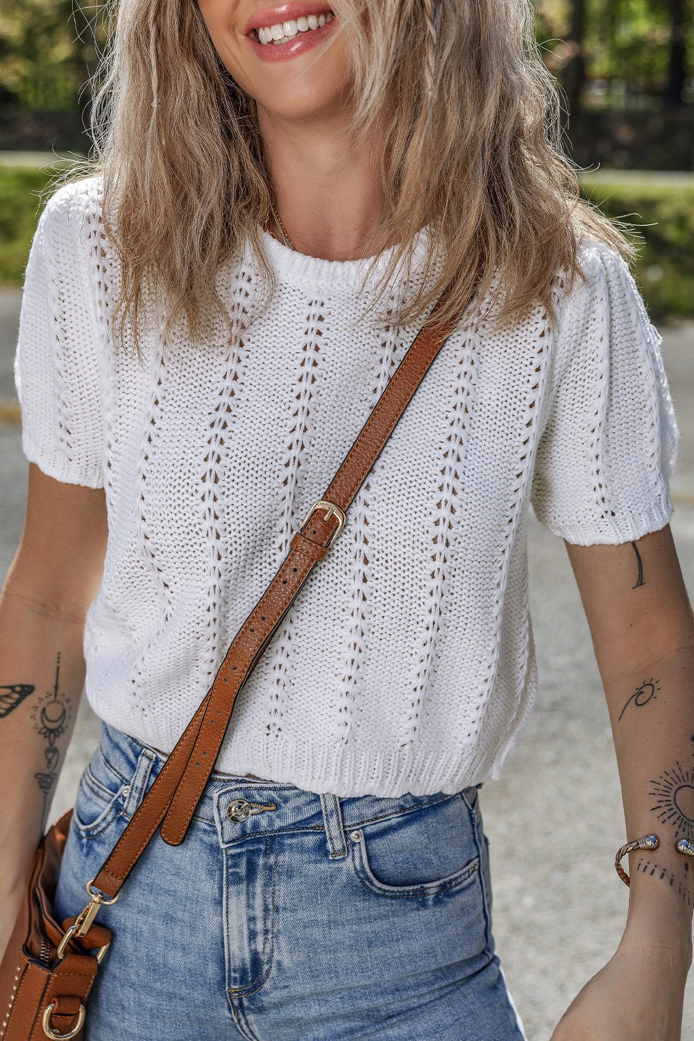 White eyelet knit puff sleeve top with a crew neck and short sleeves.