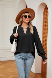 Black eyelet detail poet sleeve blouse with V-neck and smocked cuffs.