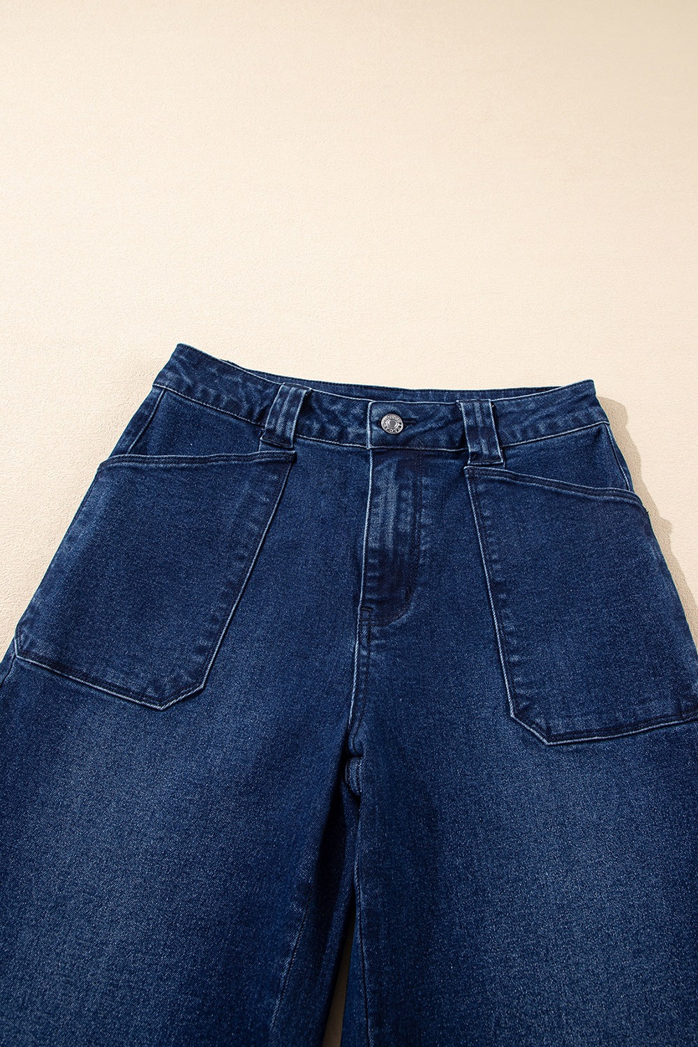Mid-rise straight leg jeans in dark wash denim with button closure and large front pockets.