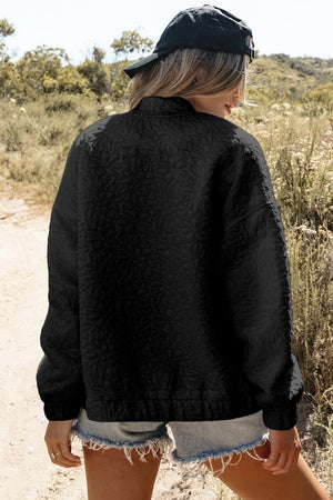 Black bomber jacket with allover embossed floral pattern and ribbed cuffs.
