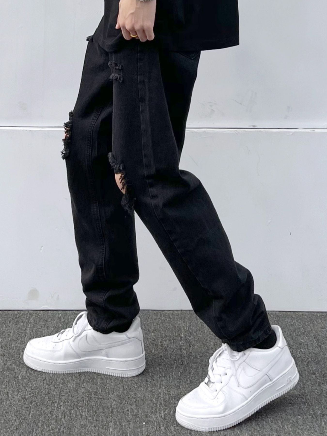Black distressed slim fit 100 cotton jeans with ripped details.