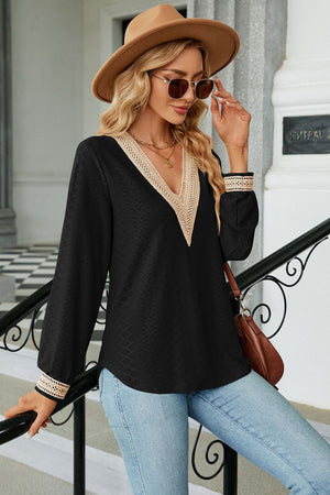 Black textured V-neck blouse with embroidered trim and long sleeves