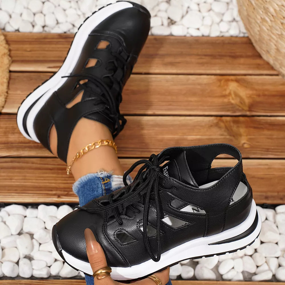 Chic black round toe lace-up sneakers with cut-out details and white soles.