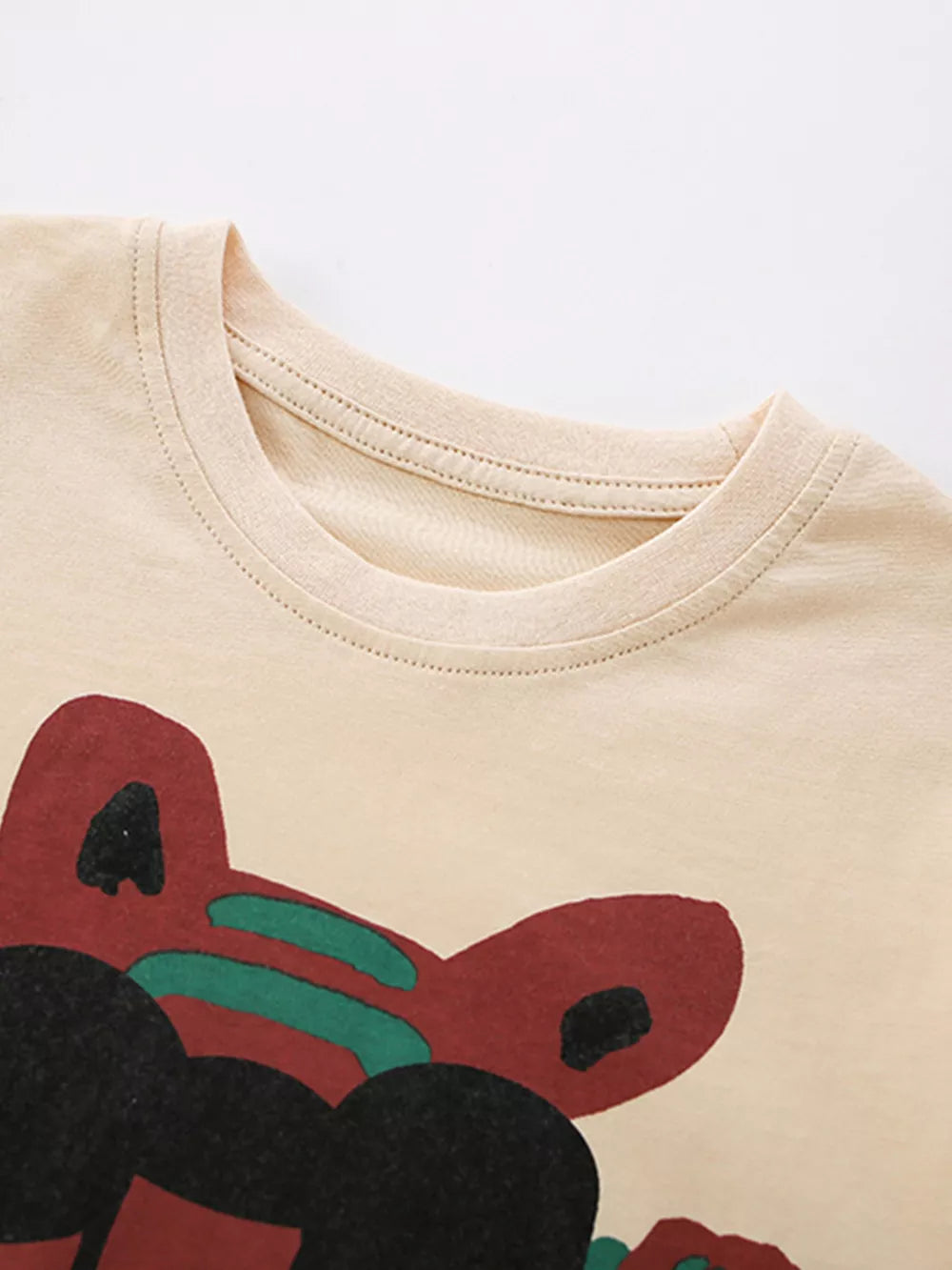 Cream cotton baby tee with whimsical tiger graphic and crew neck.