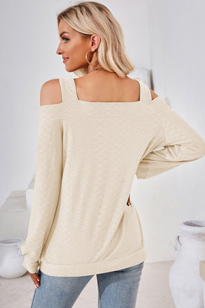 Cream geometric cutout shoulder top with long sleeves and square neckline.