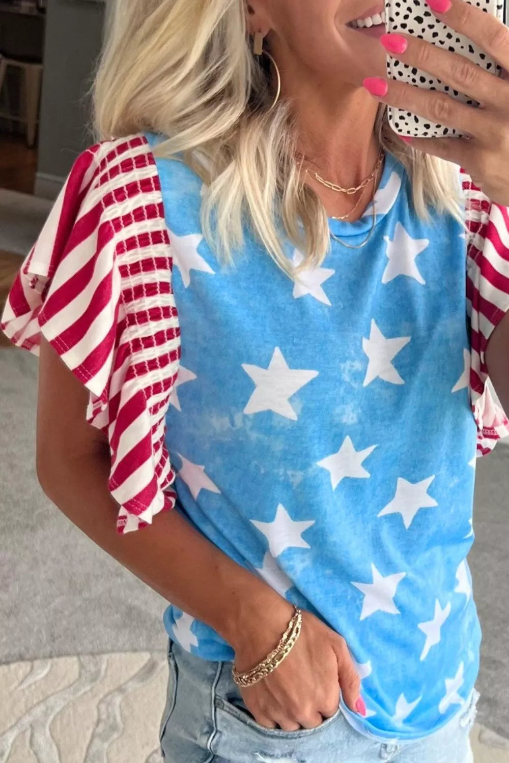 Patriotic t-shirt with blue star print and red striped ruffle sleeves.