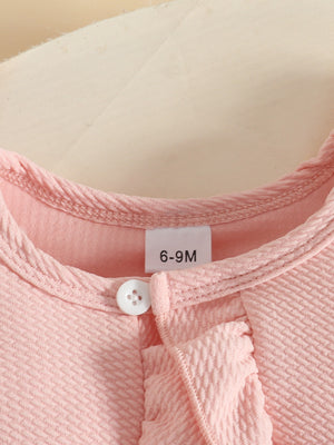 Pink baby dress and cardigan set with ruffle detail and button closure.