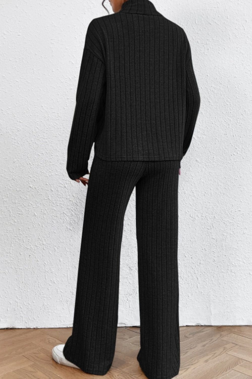 Black ribbed knit turtleneck loungewear set with wide leg pants.