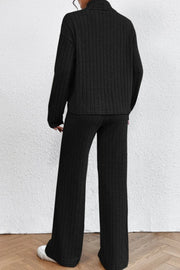 Black ribbed knit turtleneck loungewear set with wide leg pants.
