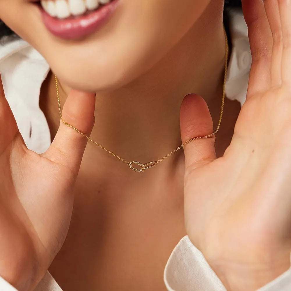 Gold interlocked link necklace with delicate chain and sparkling detail.