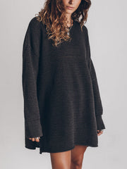 Oversized black open-knit sweater dress with crew neck and long sleeves.