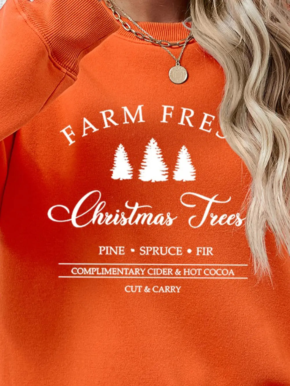 Orange graphic sweatshirt with "Farm Fresh Christmas Trees" text and pine, spruce, fir details.