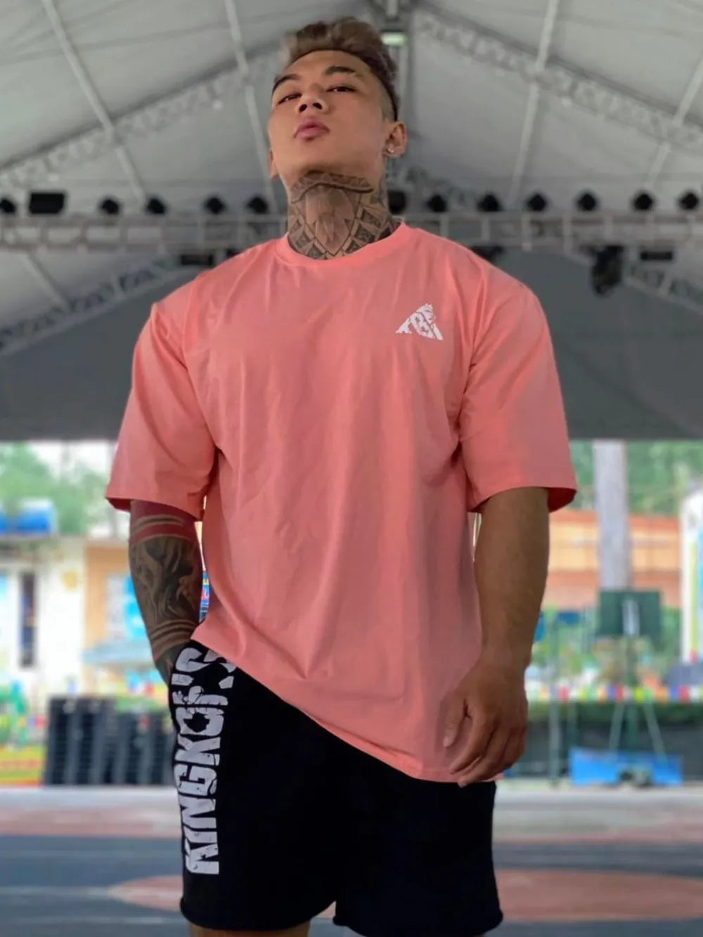 Oversized burnt coral graphic tee with a small white logo on the chest.