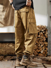 Khaki cargo pants with multiple pockets and elastic cuffs, worn by a man.