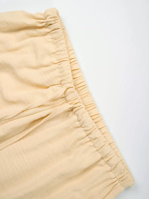 Pastel Yellow maternity pants with drawstring waist and wide legs.