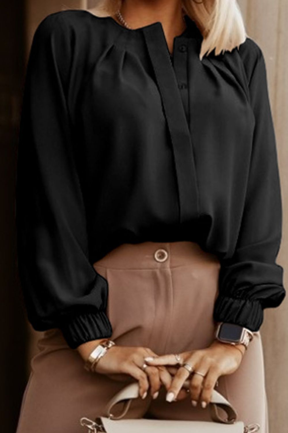 Black pleated yoke blouse with button detail and elastic cuffs.