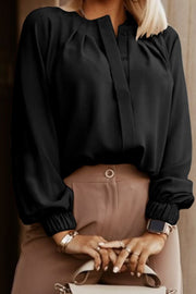 Black pleated yoke blouse with button detail and elastic cuffs.