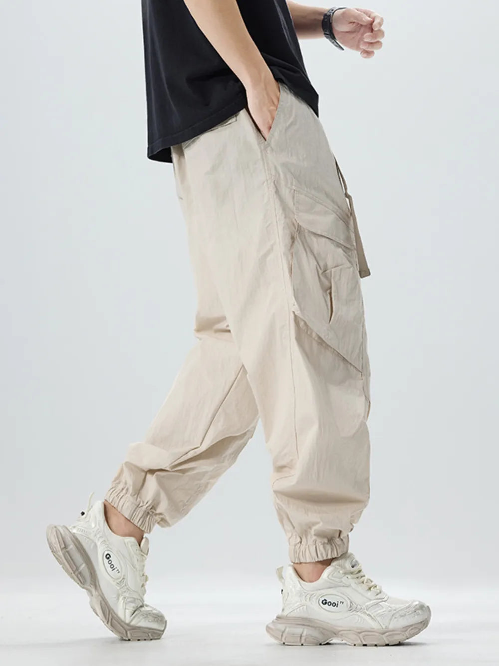 Oversized khaki cargo pants with adjustable belt and multiple pockets.