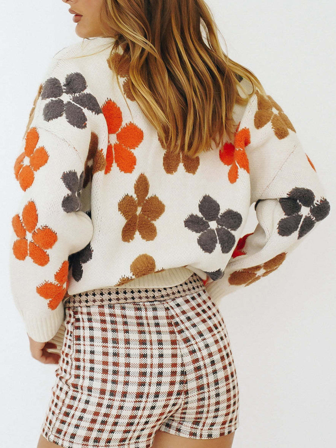 White knit cardigan with colorful floral appliqué and button-down front.