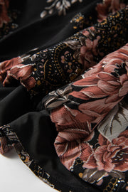 Black floral print blouse with blouson sleeves and metallic threads, showing fabric detail.