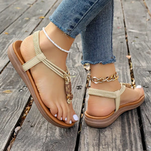 Beige embellished thong sandal with elastic strap and beaded detail.