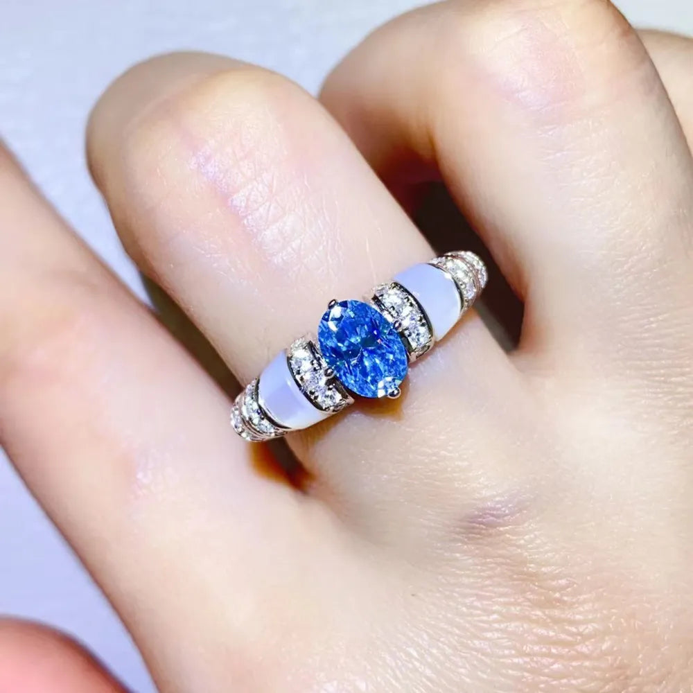 Blue oval moissanite ring with mother-of-pearl accents and diamond band