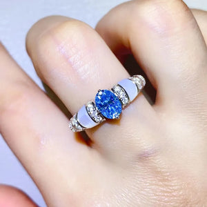 Blue oval moissanite ring with mother-of-pearl accents and diamond band