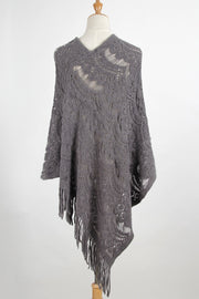Dark gray crochet poncho with intricate openwork pattern and fringe detail.