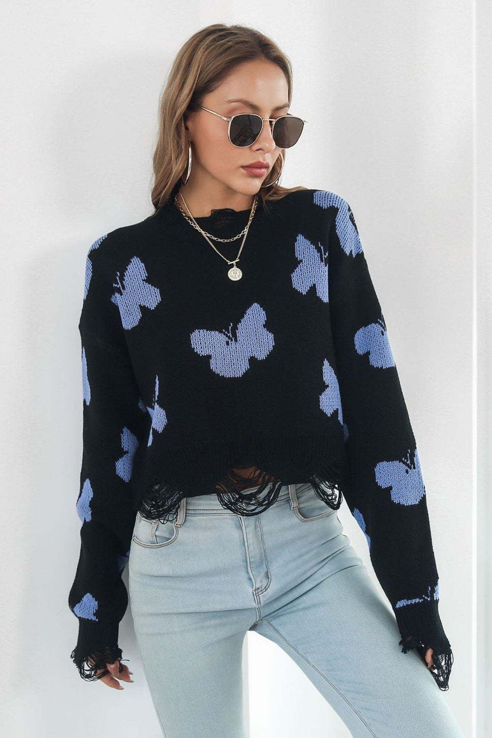 Black acrylic butterfly intarsia cropped knit sweater with frayed hem and cuffs.