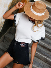 White knit t-shirt with black banded trim on neckline and sleeves.