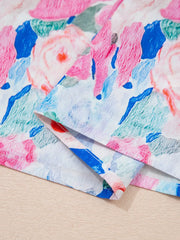 Cotton blouse with abstract floral print in pink, blue, and green.