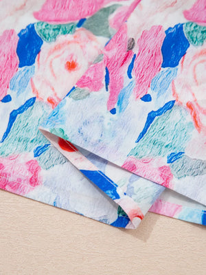 Cotton blouse with abstract floral print in pink, blue, and green.