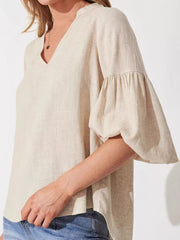 Maternity shirt in beige linen blend with notched V-neck and balloon sleeves.