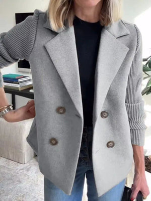 Light gray double-breasted trench coat with knit sleeves and button closure.