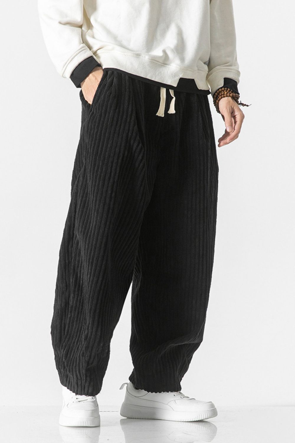 Black corduroy wide-leg cargo pants with drawstring waist and pockets.
