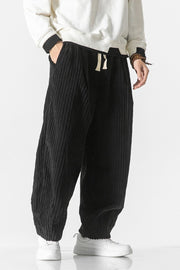 Black corduroy wide-leg cargo pants with drawstring waist and pockets.