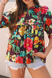 Embroidered floral babydoll blouse with colorful blooms and a V-neckline.