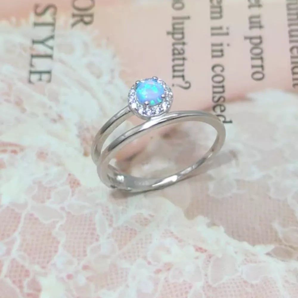 Silver ring with iridescent opal and diamond halo on double band