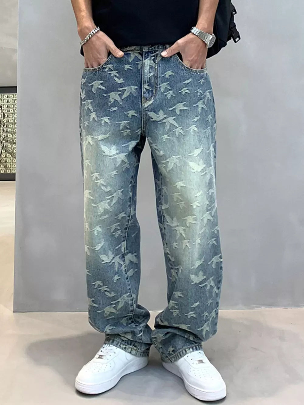 Loose-fit denim jeans with all-over bird print in light wash blue cotton.
