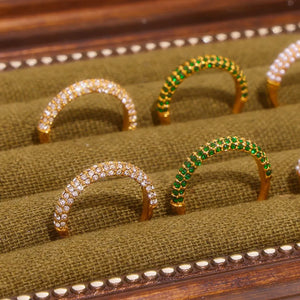 Pavé zirconia band rings in white and dark green, gold tone, detailed view