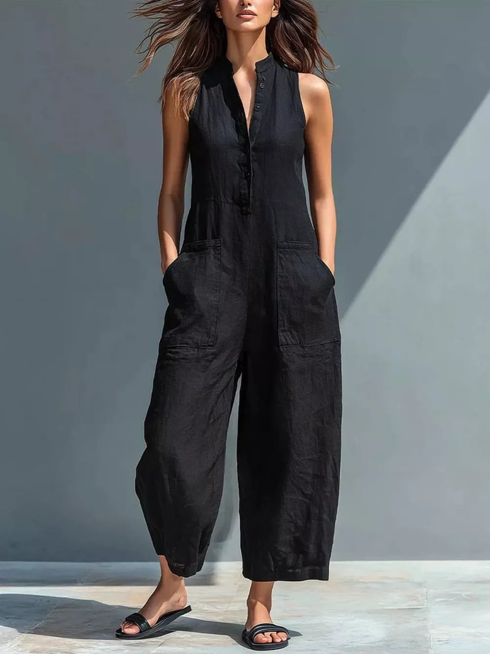 Black button-down sleeveless romper with wide legs and patch pockets.