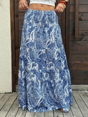 Bohemian maxi skirt in blue paisley print with tiered ruffles and smocked waist.