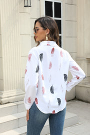 White button-down shirt with feather print, long sleeves, and collar.